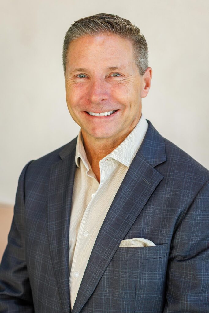A classic executive portrait of a confident businessman wearing a dark plaid suit jacket and a light-toned pocket square during a Templeton corporate headshot session.