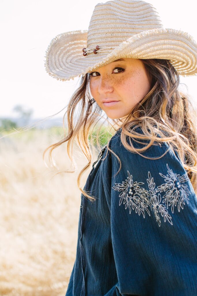 Rustic outdoor high school senior portrait of a young lady in a field, shot by Paso Robles senior photographer David Pascolla