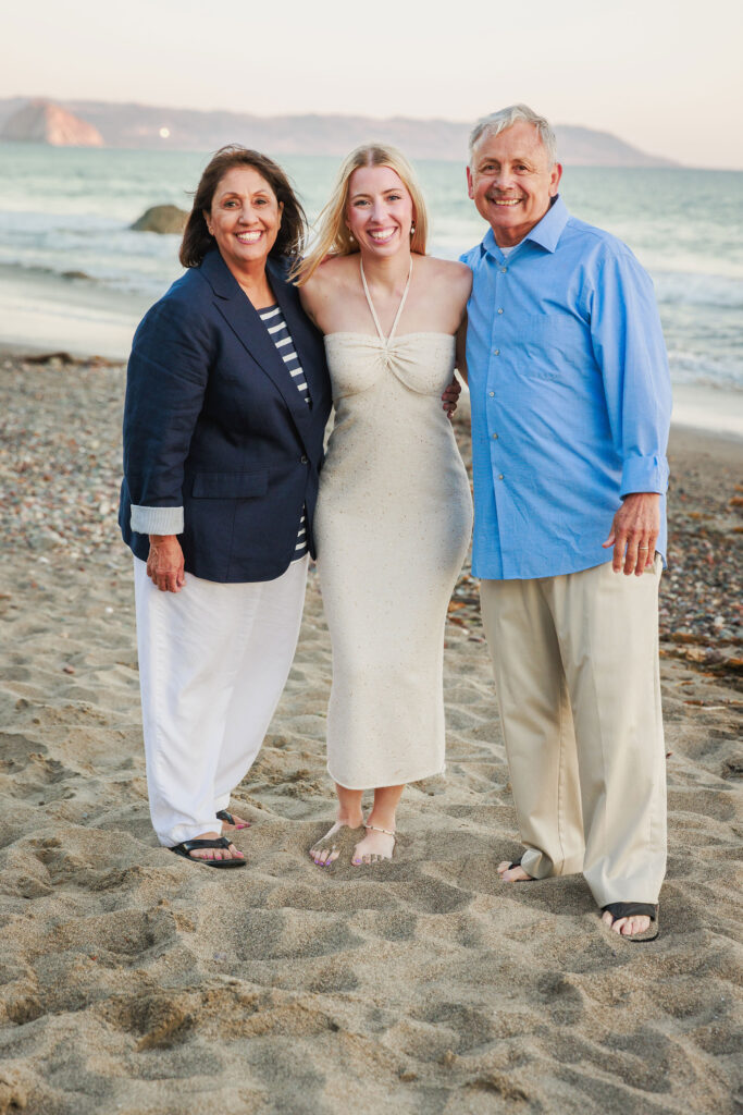 Grandparents with their granddaughter during a family portrait session on Cayucos Beach.