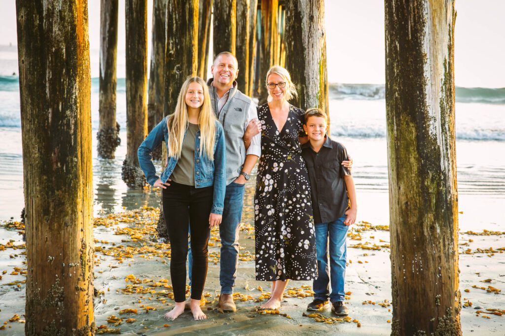 Family portraits under the cayucos pier at golden hour