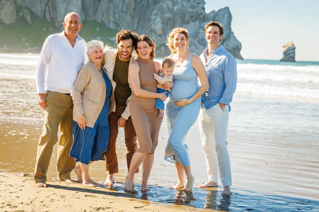 Family gathered along the shoreline during a portrait session in Morro Bay