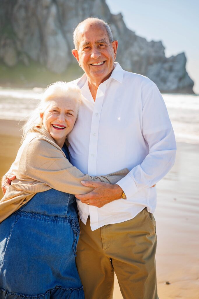 Grandparents sharing a happy moment with Morro Rock in the background